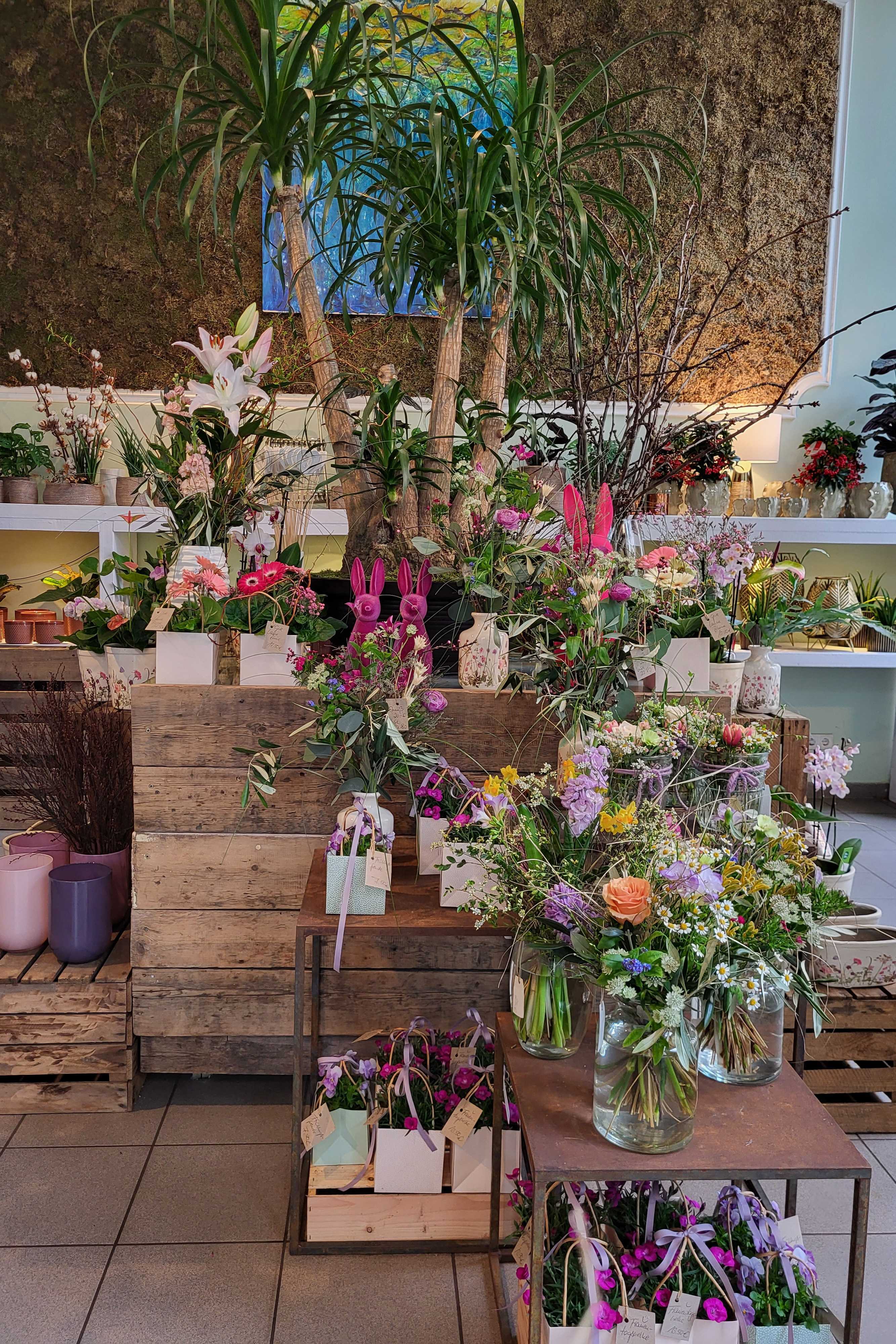 Osterdekoration mit Hasenfiguren und Frühlingsblumen